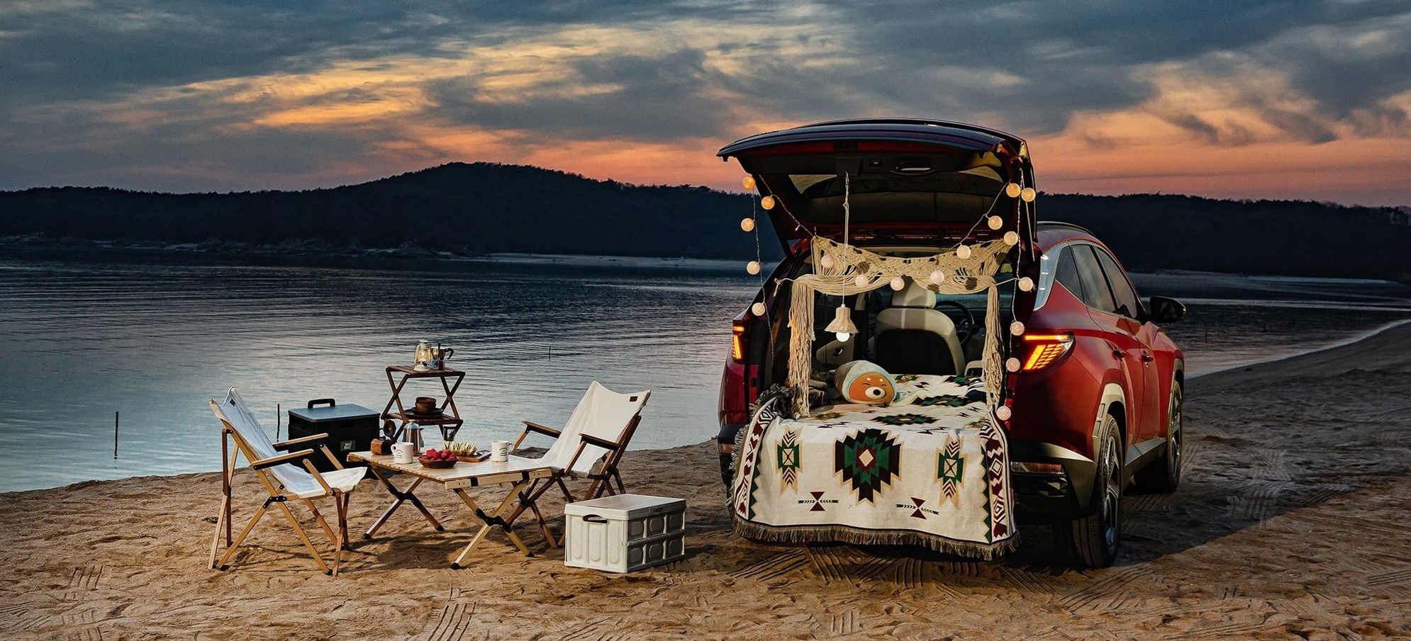 Beachside campsite with a red toyota and chairs